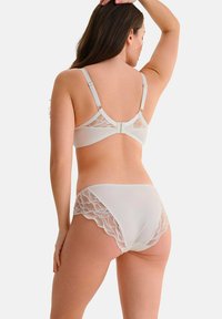 Wit lingerieset met een kanten beha en bijpassende slips. De beha heeft verstelbare bandjes en gegolfde kantdetails.