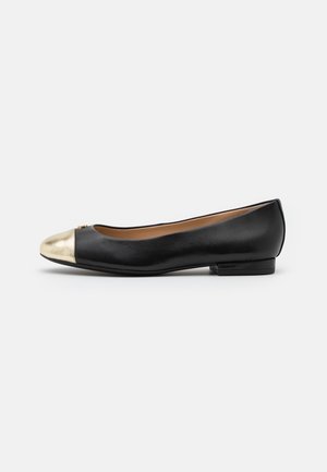 Chaussure plate en cuir noir avec embout arrondi doré métallique et petit talon, affichée de profil sur fond blanc.