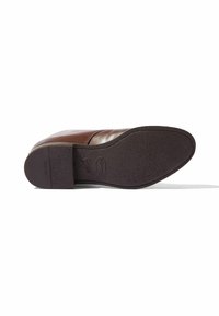 Suela de zapato de cuero marrón con superficie texturizada, que presenta una punta redondeada y la marca Vibram cerca del talón.