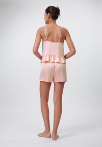R�ózsaszín selyem loungewear szett fodros toppal és sorttal. Könnyű anyag, állítható pántokkal, sima tapintású és laza fazonú.