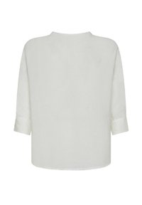 Blusa bianca, ampia e fluida, con scollatura rotonda e maniche a tre quarti, realizzata in un tessuto leggero con una trama liscia, senza motivi visibili.
