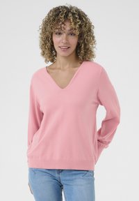 Maglione rosa chiaro a V con maniche lunghe, realizzato in un materiale morbido, caratterizzato da una vestibilità comoda e un orlo a coste.