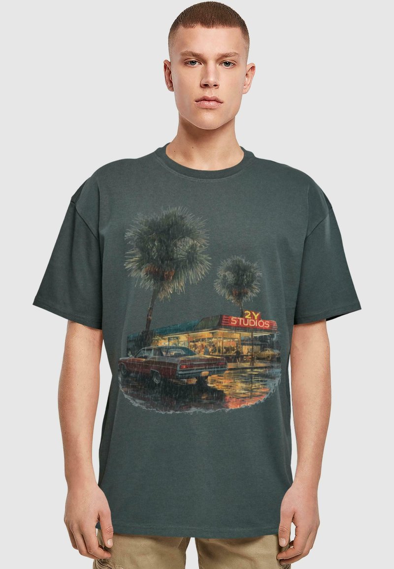 Donkergrijze katoenen t-shirt met een graphic van palm bomen en een vintage auto voor een studio, met kleurrijke winkeltijdschrift.