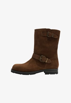 Smeđe antilop čizme do gležnja s zaobljenim prstima, dvije dekorativne trake i kopče, te niskom blok petom. Glatka tekstura i minimalistički dizajn.