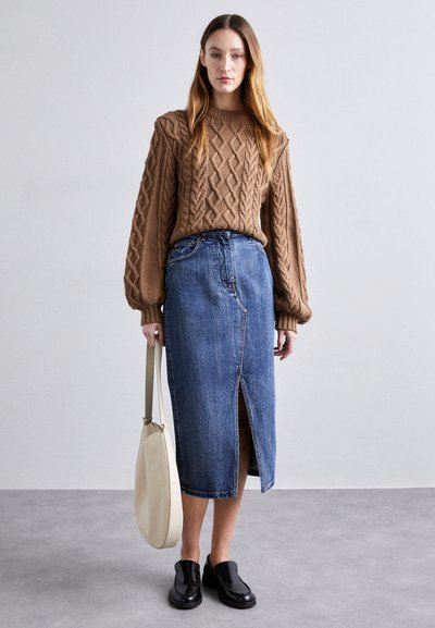 Brun kabelstrikket genser, høy midje denimskjørt med frontspalte, svarte slip-on sko og kremfarget totebag. Glatte teksturer og uformell design.