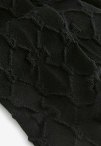 Tejido de punto negro con un patrón texturizado que presenta un motivo de diamante. Acabado suave, ligeramente difuso, con acentos deshilachados en toda su extensión.