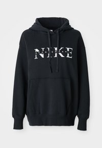 Crna Nike dukserica s kapuljačom, prednjim džepom, velikim logotipom preko grudi, te rebrastim manžetama i donjim rubom. Mekani kombinirani materijal od pamuka.