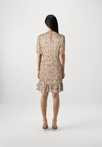 Robe à imprimé floral avec des manches courtes bouffantes, un ourlet volé et une fermeture en goutte d'eau à l'arrière, fabriquée en tissu léger.