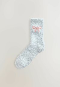 Svetlomodrá huňatá ponožka s jemnou štruktúrou, na boku s ružovým vyšitým vzorom mašličiek. Design do členkov.