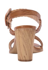 Sandal in pelle marrone con cinturino intrecciato alla caviglia, fibbia in tonalità argento e tacco a blocco in legno grosso visto da dietro.
