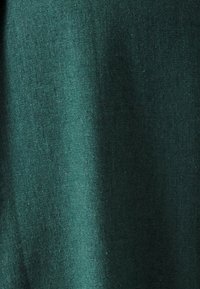 Dark green fabric with a smooth texture, showing a woven pattern. The material appears lightweight and slightly reflective.