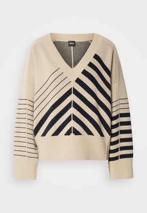 Beige gebreid V-halstrui met zwarte diagonale en horizontale strepen, voorzien van brede mouwen en geribbelde manchetten. Merkenlabel: BOSS.