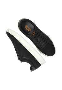 Schwarze Leder-Sneaker mit strukturiertem Finish, ausgestattet mit einer weißen Gummisohle, runden Schnürsenkeln und einem orangen Logoetikett im Inneren des Schuhs.