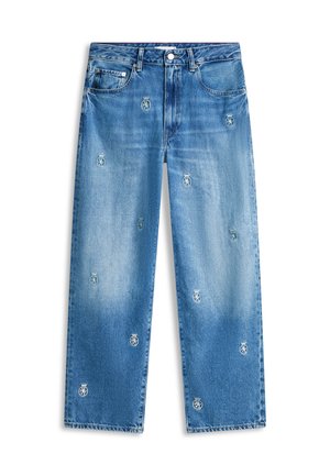 Jean bleu coupe droite avec un lavage délavé et de petites armoiries brodées dispersées sur le devant.