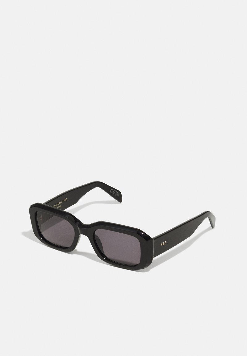 Black rectangular sunglasses with a thick frame, dark tinted lenses, and gold accents on the arms. Made from plastic with a glossy finish.