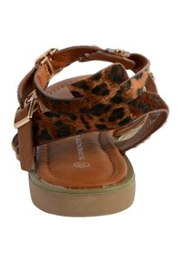 Sandal marrone con cinturino in pelliccia leopardata, fibbia regolabile e soletta cushioned. Suola piatta con una leggera texture.