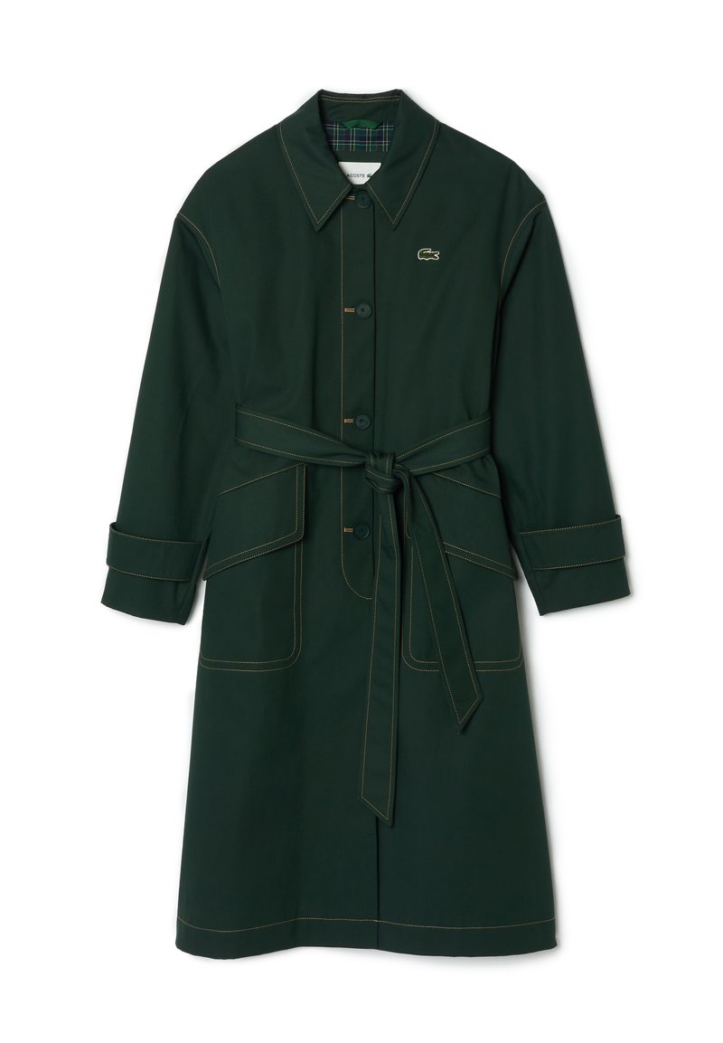 Manteau vert foncé avec fermeture à boutons, taille ceinturée, deux poches avant et manches retroussées. Présente des coutures dorées contrastantes et une doublure à carreaux.