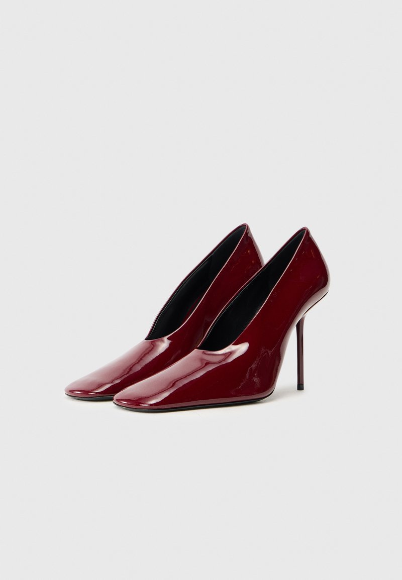 Bordeaux højhælede pumps med en blank patentfinish, spidse tæer og et strømlinet, minimalistisk design. Sort indvendig foring.