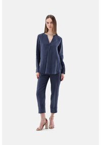 Marineblaue Leinenbluse mit V-Ausschnitt und langen Ärmeln, kombiniert mit passenden, schmal zulaufenden Hosen; verfügt über einen lässigen Schnitt und eine dezente Textur.
