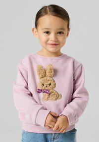 hele roosa pusa, millel on tekstuuriga tikitud jänese kujutis suurete kõrvade ja lilla paelaga. Pehme kangas, ümar kaelus ja soonikkoes varrukasääred.