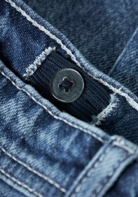 Vita abbottonata in denim scuro con dettagli di cuciture visibili, che mostrano un tessuto strutturato e un bottone nero con un design a quattro punte.