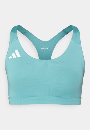 Soutien-gorge de sport bleu clair avec un décolleté bateau et un design dos nageur. Présente des accents de logo blancs sur le côté gauche et un tissu lisse et extensible.
