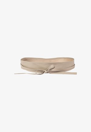 Ceinture large en cuir beige avec une fine lanière nouée en nœud à l'avant, posée à plat sur un fond blanc.