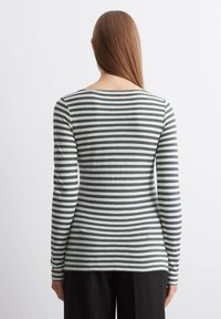 Langsleeve top in grijs en witte strepen. Gemaakt van zachte materialen met een bootnek en een getailleerd ontwerp. Regular lengte zoom op de heupen.