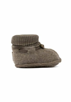 Pantoufle en laine marron avec un revers en tricot, présentant une pointe arrondie, des coutures visibles et un petit bouton décoratif sur le côté.