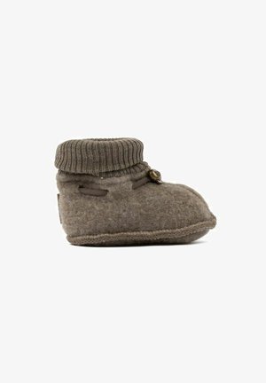 Bruine wollen slipper met een gebreide manchet, voorzien van een ronde neus, zichtbare stiksels en een kleine decoratieve knop aan de zijkant.