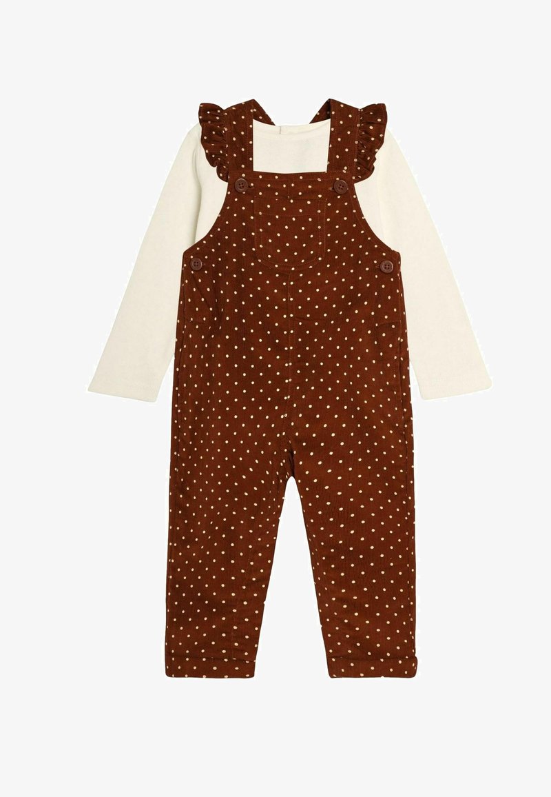 Pruunid korduroy kombinesoonid valgete täppidega, millel on volangidega rihmad, ruudukujuline kaelus ja nööbid õlgadel; koos valge särgiga.