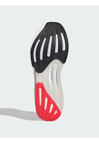Shoe sole with a black rubber base, red accents, and white grooves, featuring a textured design for traction and stability.