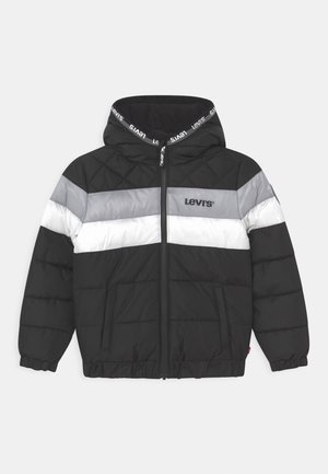 Veste matelassée noire avec des rayures horizontales grises et blanches, fermeture éclair à l'avant, capuche avec ruban logo Levi's, et logo Levi's sur la poitrine.
