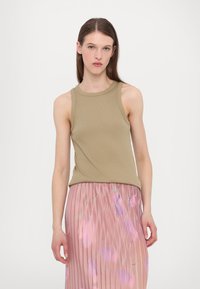Khaki linne i ribbat tyg, matchad med en rosa plisserad kjol med abstrakta blommönster i lila och gröna nyanser.