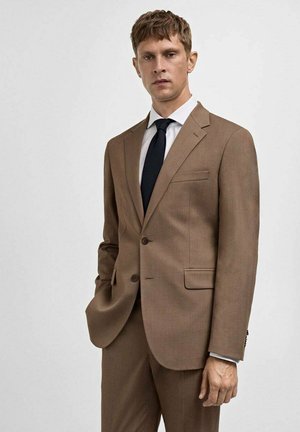 Brown tailored suit with two buttons, notch lapels, pocket detail, slim fit, paired with a white shirt and black tie. Textured fabric.
