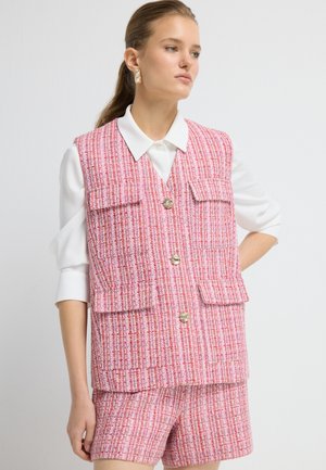 Rosa Tweed-Weste mit zwei vorderen Taschen, silbernen Knöpfen und einem weißen Kragenhemd darunter. Texturiertes Gewebe mit einem karierten Muster.