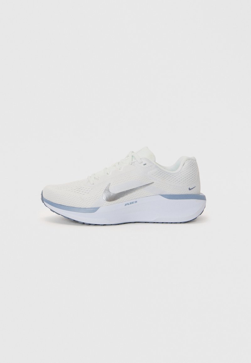 White athletic shoe with a textured mesh upper, silver accents, and a light blue sole. Features round laces and a cushioned heel.
