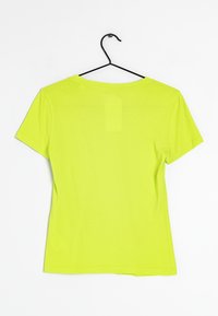 Korte mouw t-shirt in fel neon groen stof, met een ronde hals, een gladde textuur en zonder zichtbare patronen of accenten, hangen aan een zwarte haak.