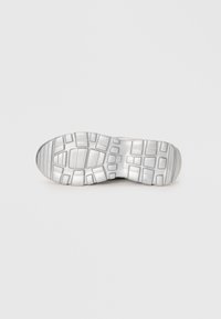 Gummisåle til sneakers, lys grå med dype, rektangulære mønstre og en jevn tekstur, som gir grep og holdbarhet.