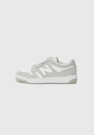 Baskets pour hommes avec une tige blanche et des accents gris, présentant une texture perforée, un logo signature et une semelle en caoutchouc.