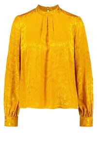 Blouse jaune à manches longues en tissu texturé. Elle présente un col montant, un devant plissé et des poignets froncés. Motif floral subtil sur toute la surface.