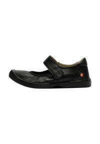 Zapato de cuero negro con puntera redonda, cierre de correa y suela negra flexible con pequeñas perforaciones para un mejor agarre.