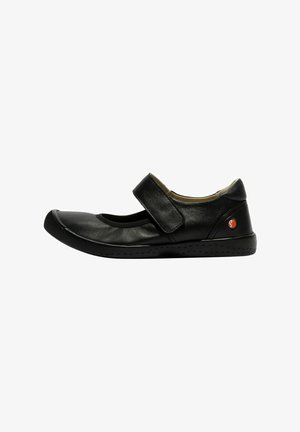Zapato de cuero negro con puntera redonda, cierre de correa y suela negra flexible con pequeñas perforaciones para un mejor agarre.