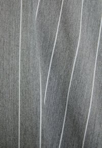 Szary materiał z cienkimi, białymi pionowymi prążkami i delikatną tkacką teksturą, lekko złożony w centrum.