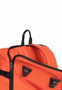 Sac à dos orange vif avec fermeture zippée noire, deux clips en plastique noirs sur la poche avant et une anse en tissu noir en haut.