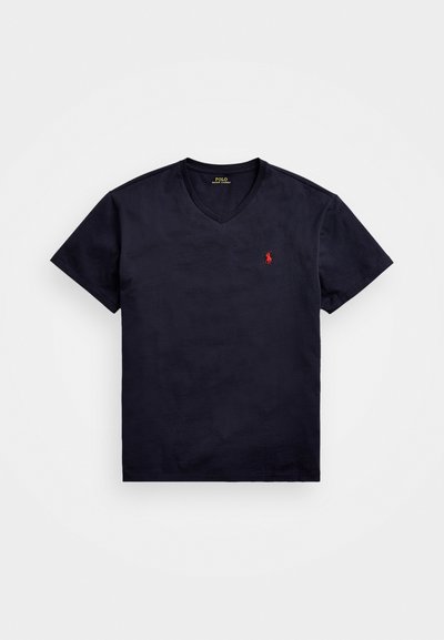 Marinblå kortärmad V-ringad t-shirt i bomull, med en liten röd broderad logotyp på vänster bröst. Slät textur.