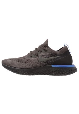 Ciemnoszary but do biegania Nike z dzianinową cholewką, czarną podeszwą, niebieskim akcentem na pięcie i sznurowadłami, pokazany z profilu na białym tle.