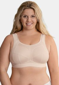 Top sportivo beige con spalline larghe, pannelli in rete e coppe rinforzate. Progettato per offrire supporto con una finitura senza cuciture e una banda elastica in fondo.