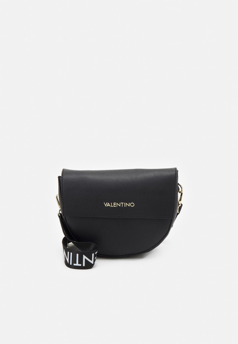 Černá polokruhová crossbody kabelka Valentino se zlatým logem na klopě a širokým černým popruhem se bílým brandingovým textem.