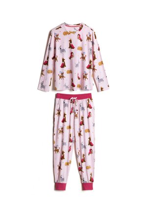 Femme aux cheveux blonds portant un pyjama rose clair avec divers chiens illustrés en costumes, levant un bras au-dessus de sa tête.